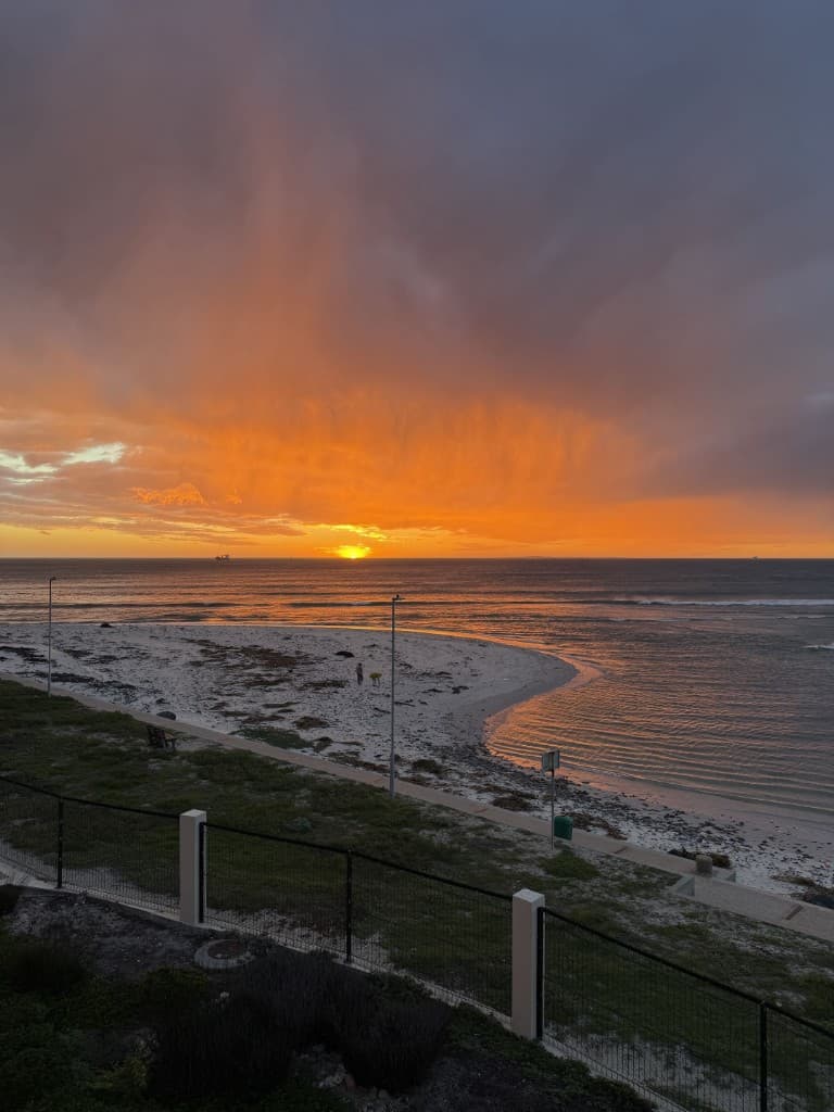 The sun setting into the Atlantic over an empty beach